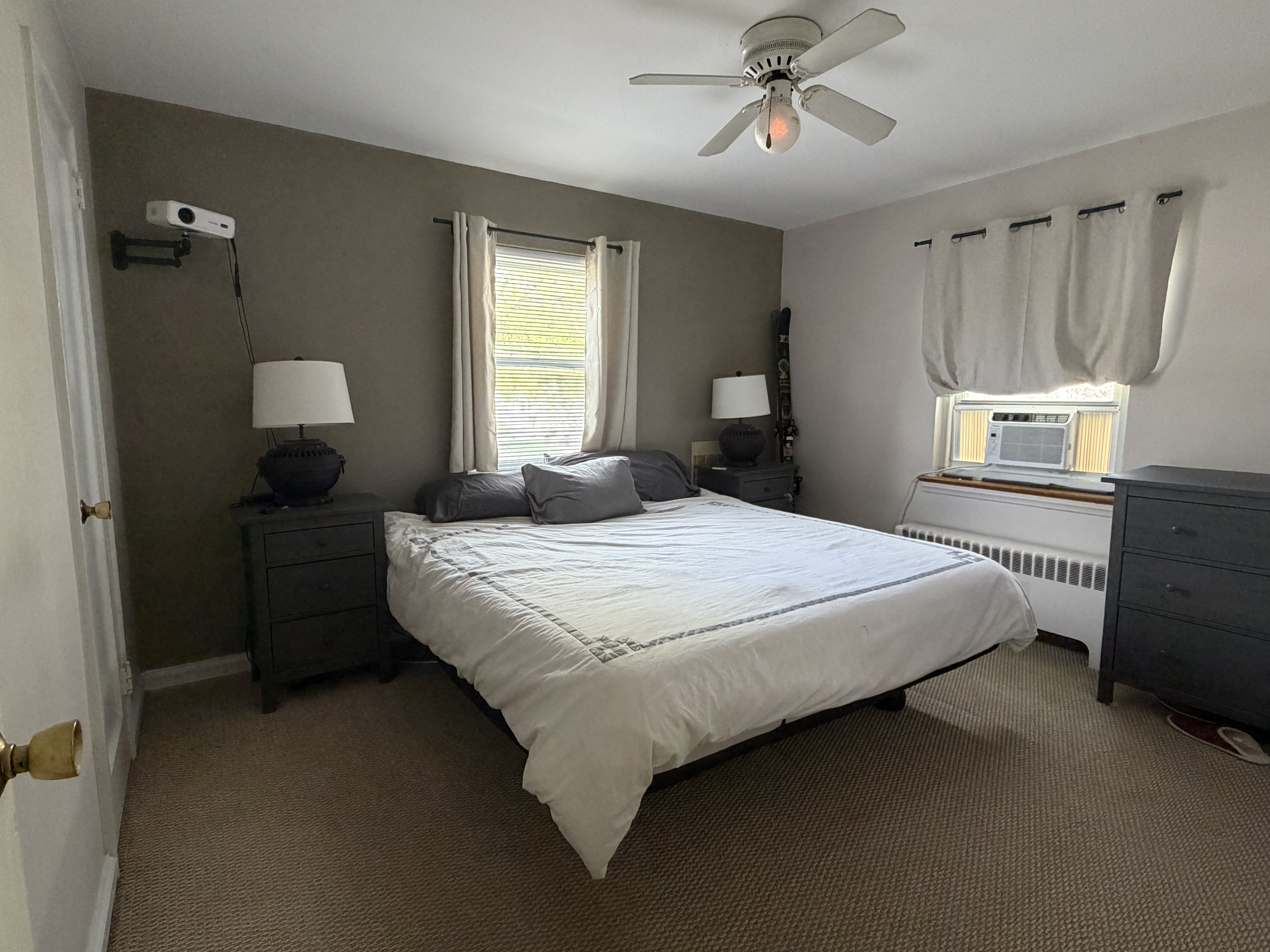 King-size bedroom with ceiling fan and ample natural light